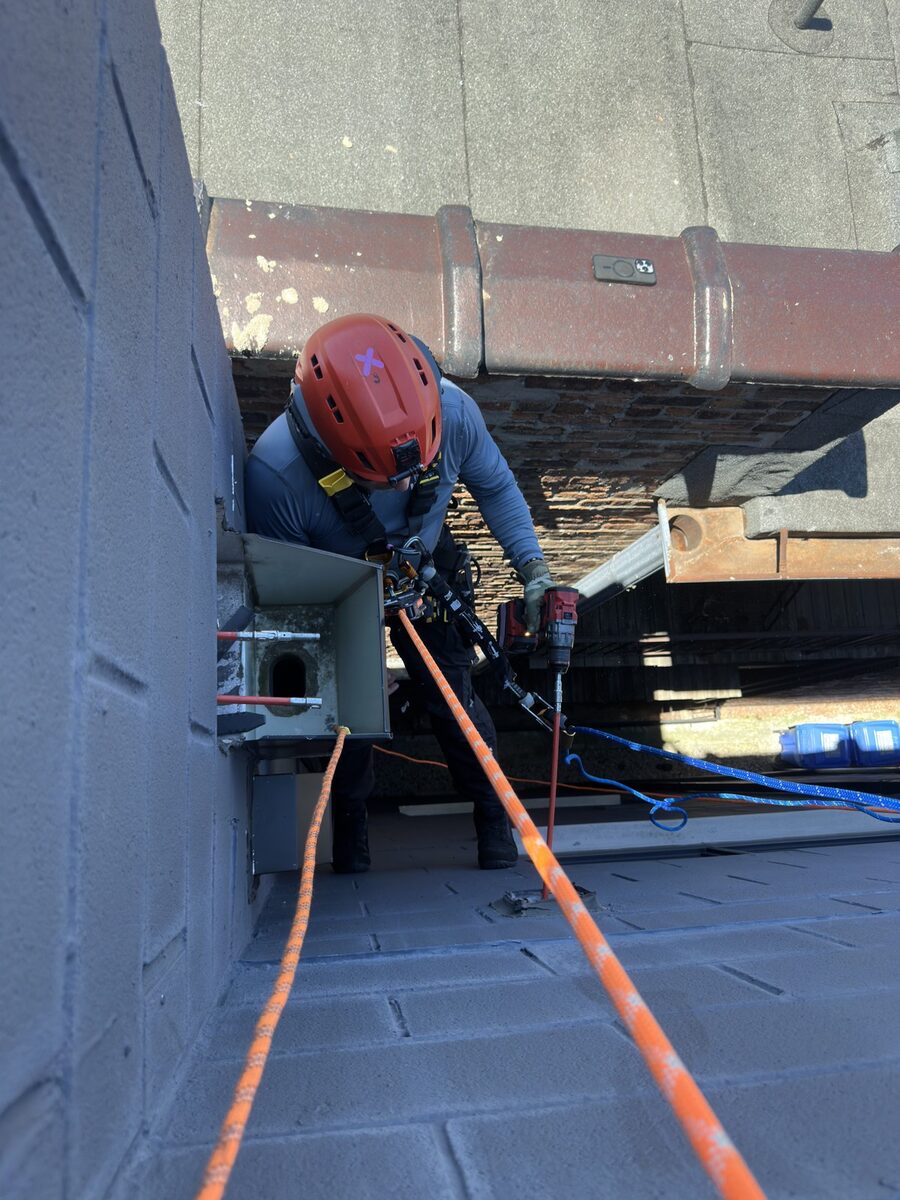 Rope access technician repairing a vent at height
